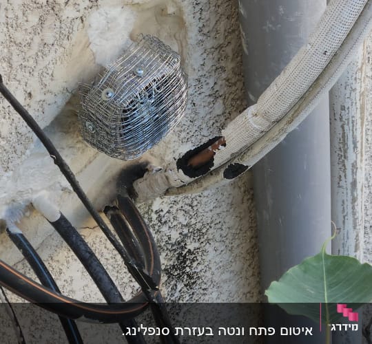 צינור אפור, כבלים שחורים, רשת מתכת על קיר